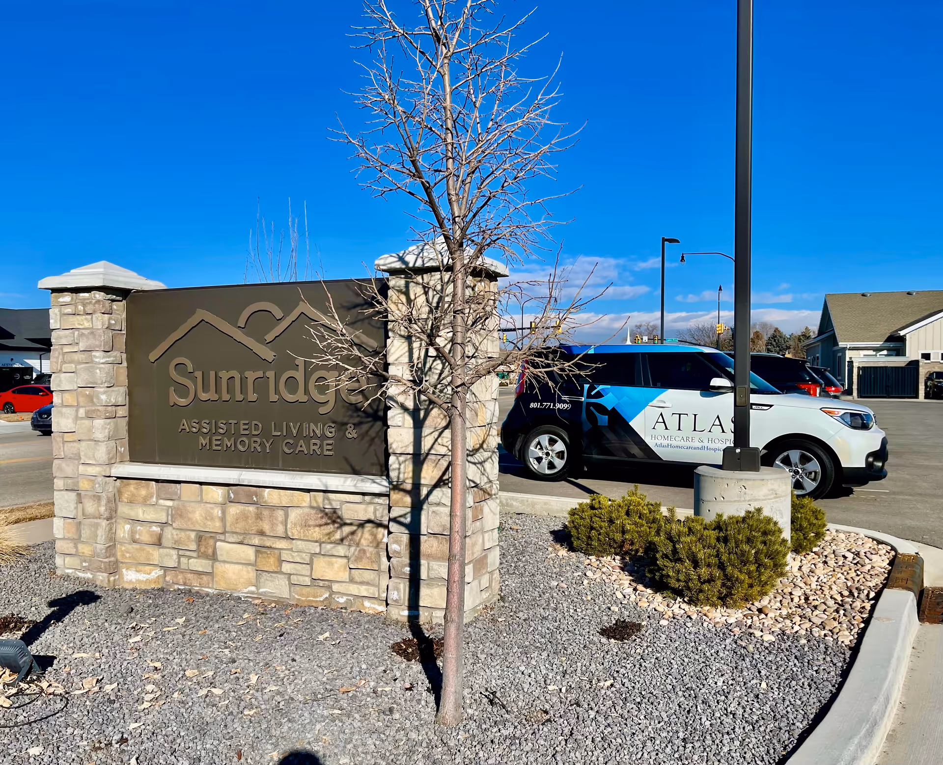Exterior view of the Sunridge sign and Atlas Homecare vehicle in the parking lot.