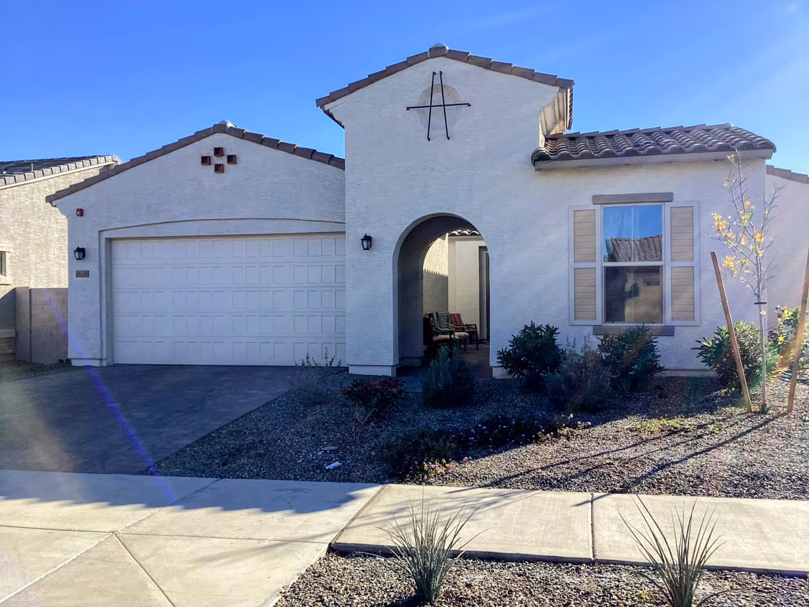 Front exterior of a single-story assisted living home with an arched entry and garage.