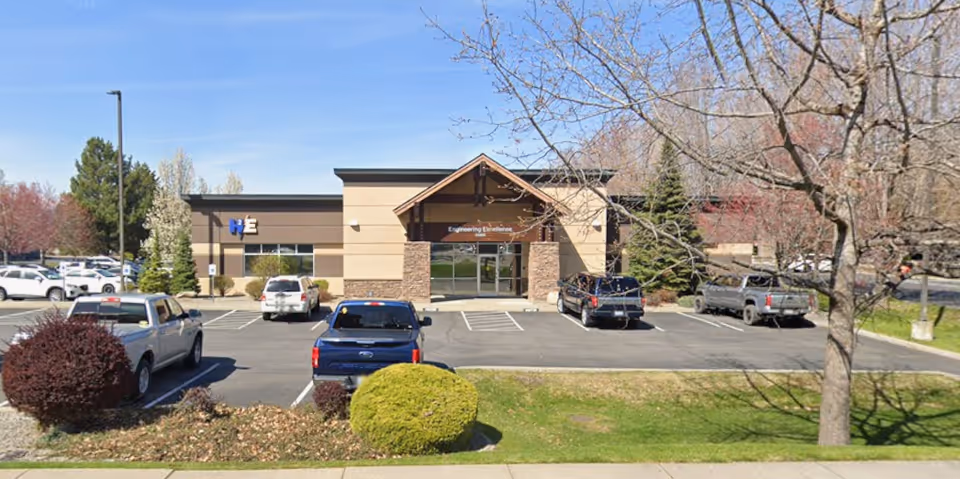 Exterior view of a single-story office building with a parking lot.