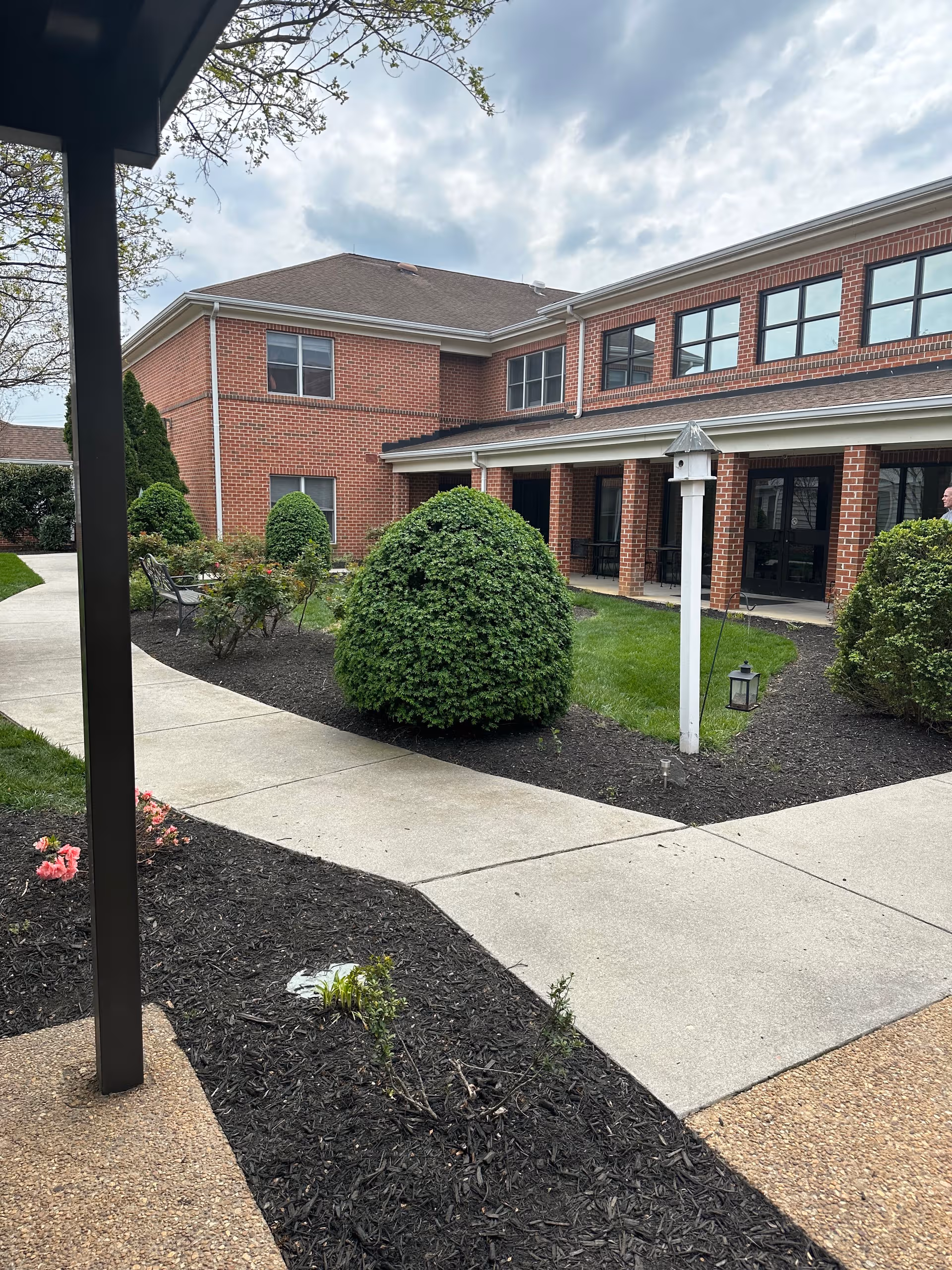 Exterior view of Saint Francis Manchester building with brick walls, walkway, and landscaped shrubs.