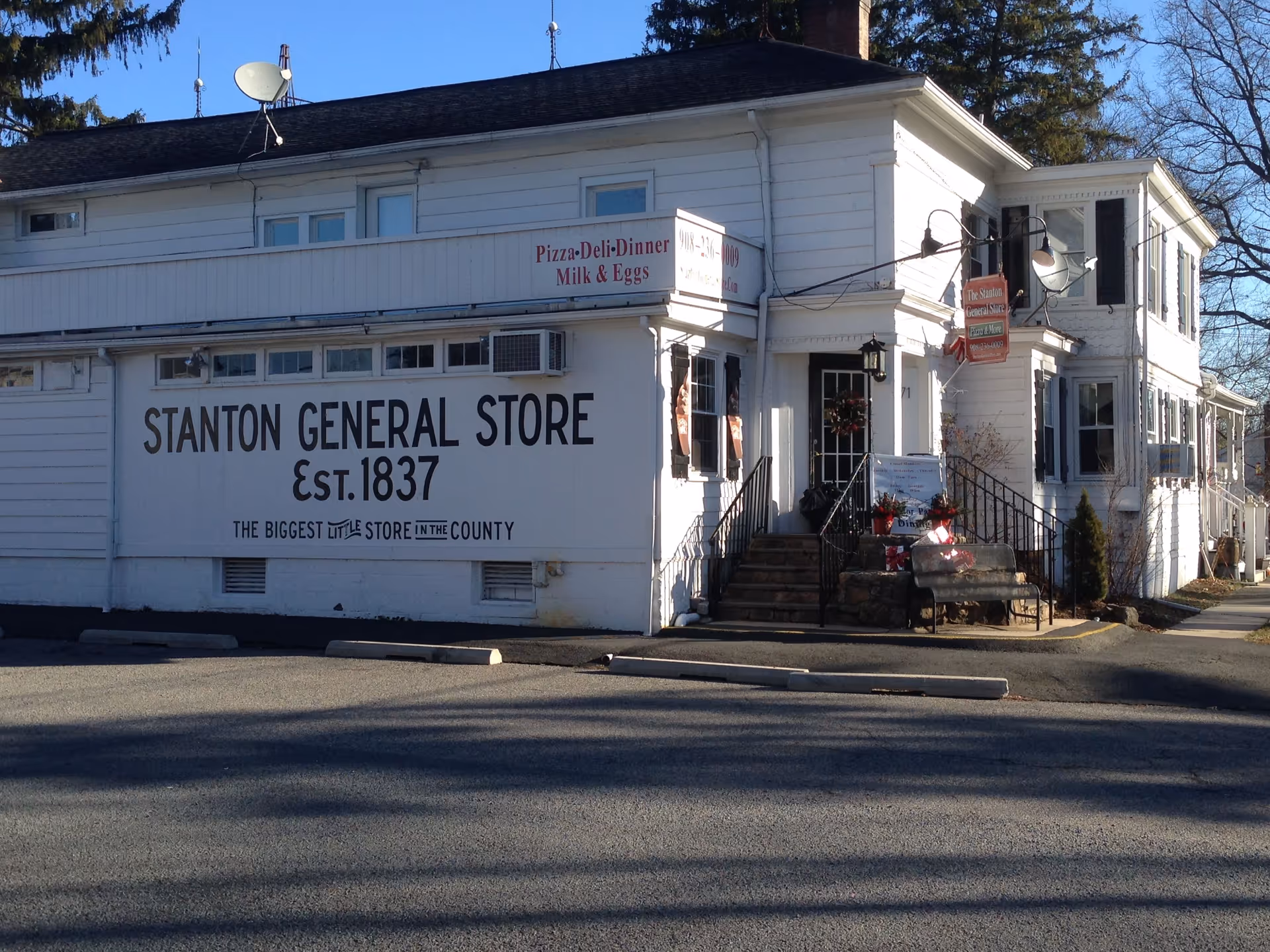 Two-story white general store with Stanton General Store sign, front steps, and street view.