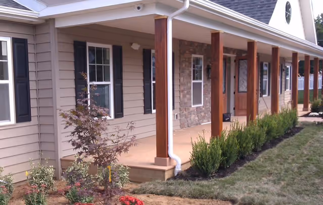 Exterior view of a single-story senior living facility with a covered porch and columns.