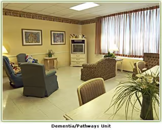 A cozy interior living area with recliners, a TV, and large windows.