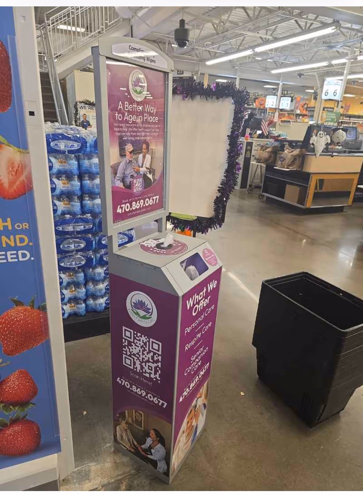 Purple information kiosk promoting elder care sits beside checkout in a store.