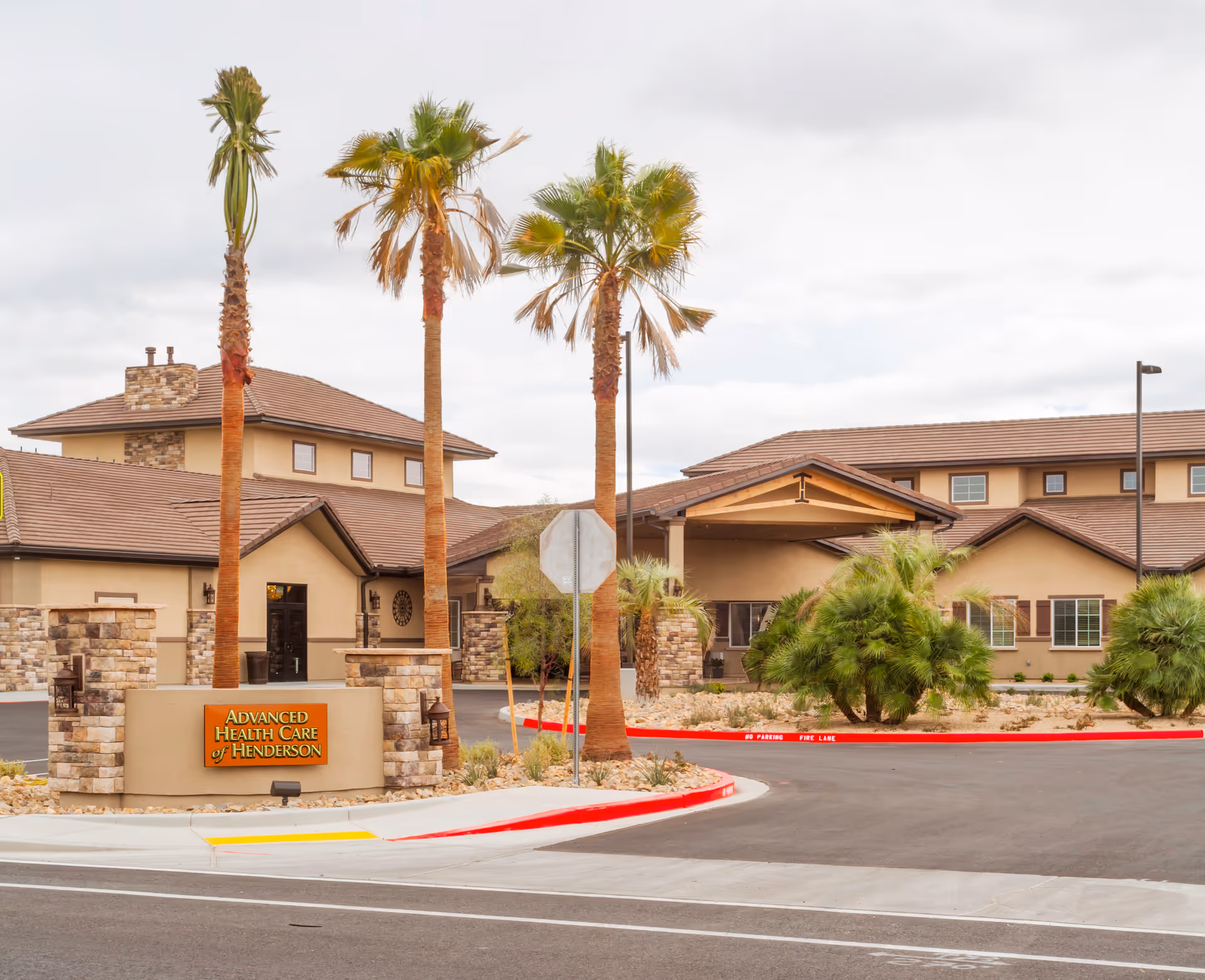 Exterior view of Advanced Health Care of Henderson with palm trees and main entrance.