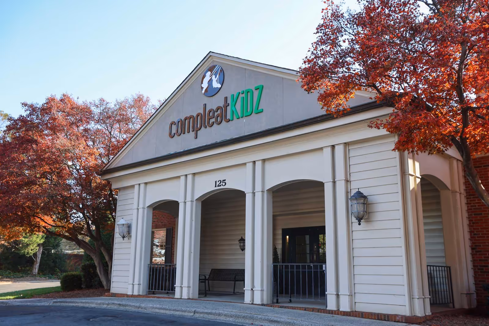 Exterior view of a beige building with arches and a CompleatKiDZ sign.