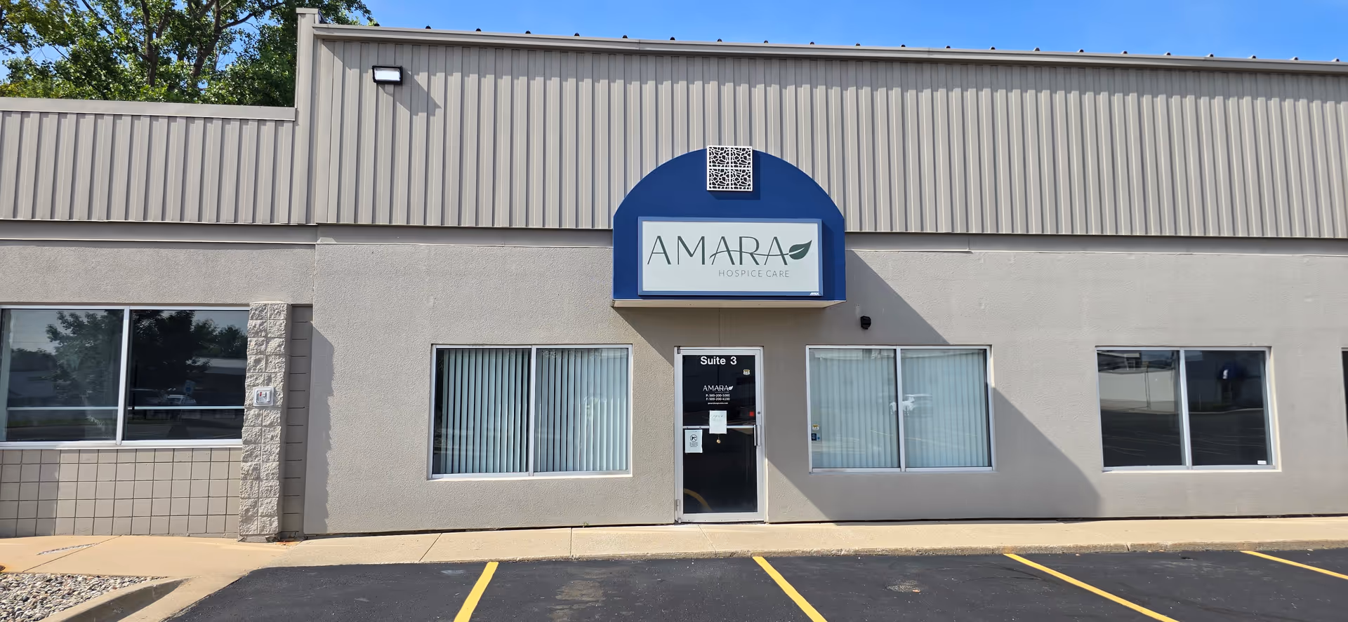 Front exterior view of Amara Hospice facility with blue sign and parking lot.