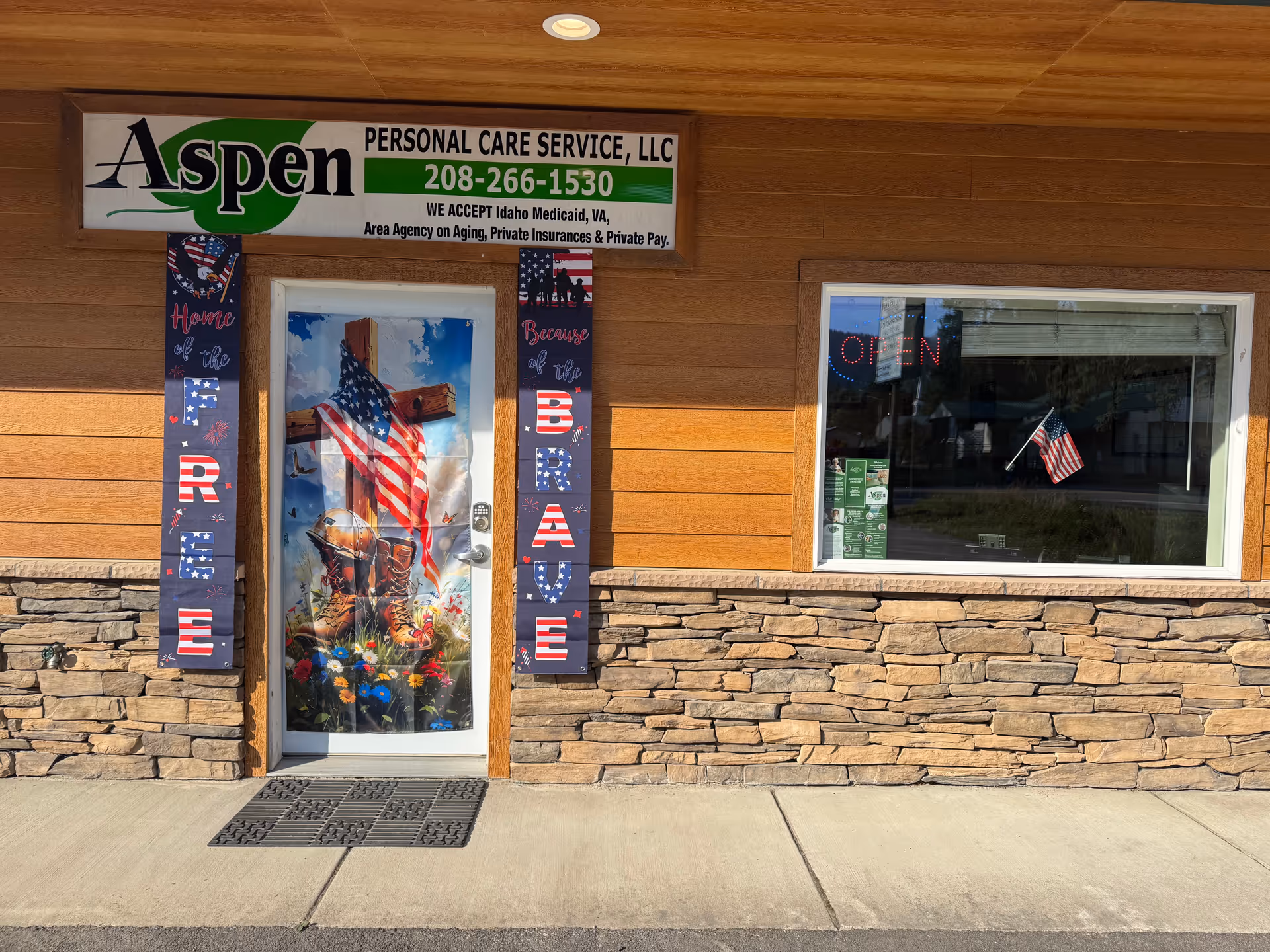 Exterior view of Aspen Personal Care Service LLC storefront with patriotic decorations at the entrance.