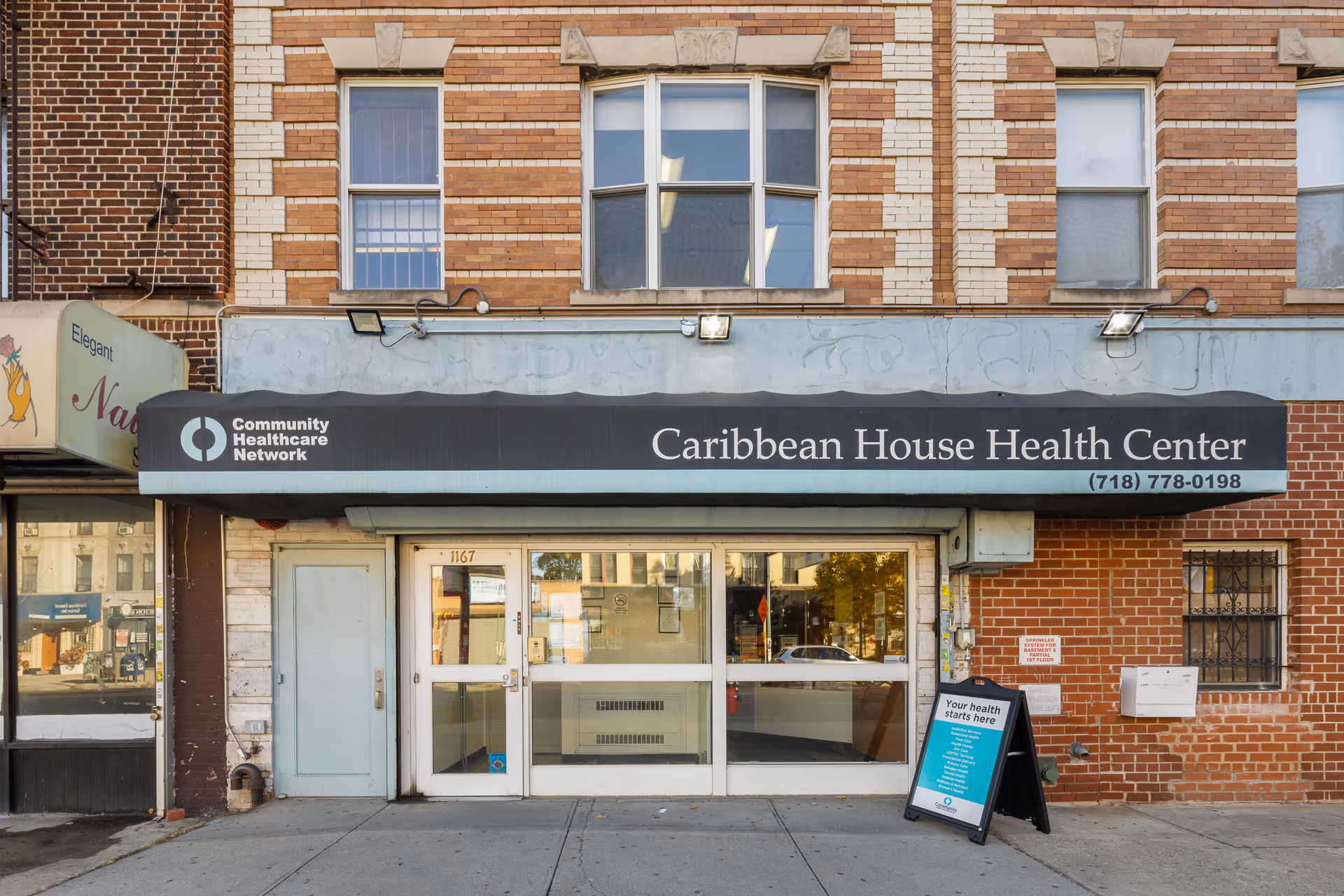 Exterior view of Caribbean House Health Center storefront with signage and a sidewalk.