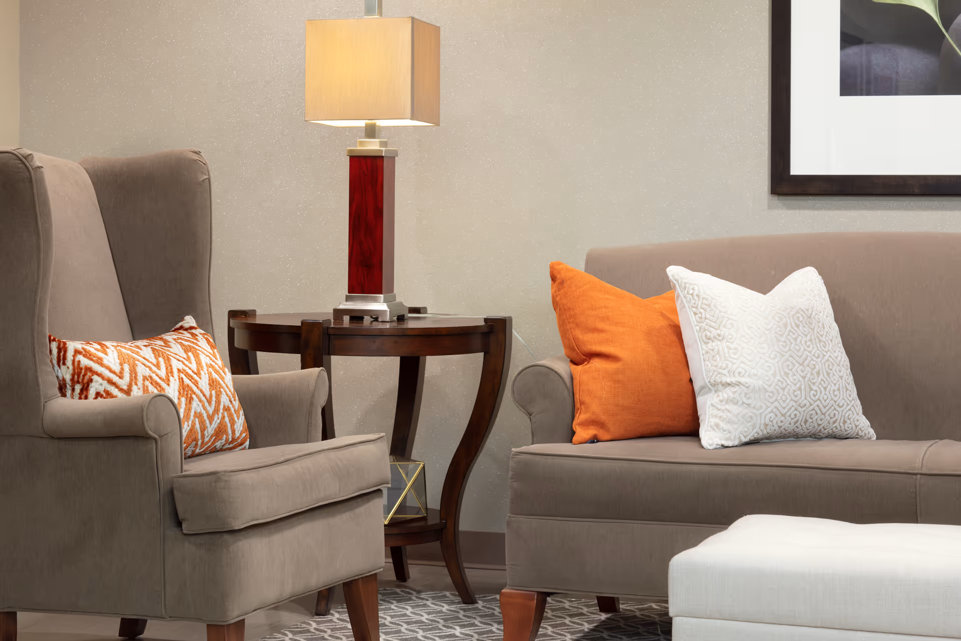 A cozy living room seating area with armchairs, a sofa, and a lamp.