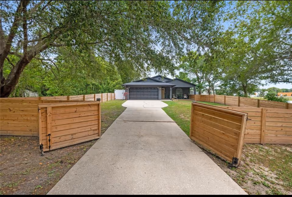 Wide driveway leads to Margarita’s Angels Assisted Living Facility with wooden privacy fences.