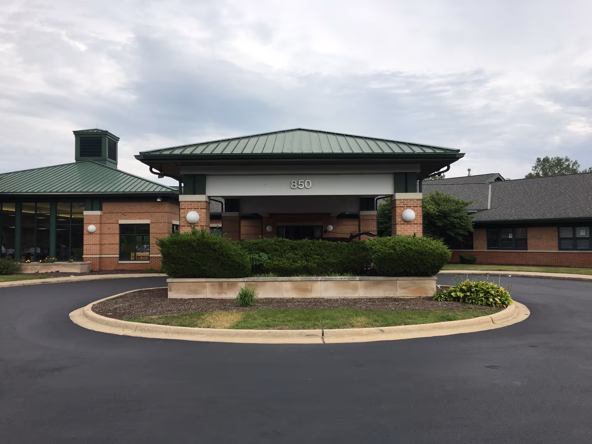 Exterior view of a senior living facility with circular driveway and entrance canopy.