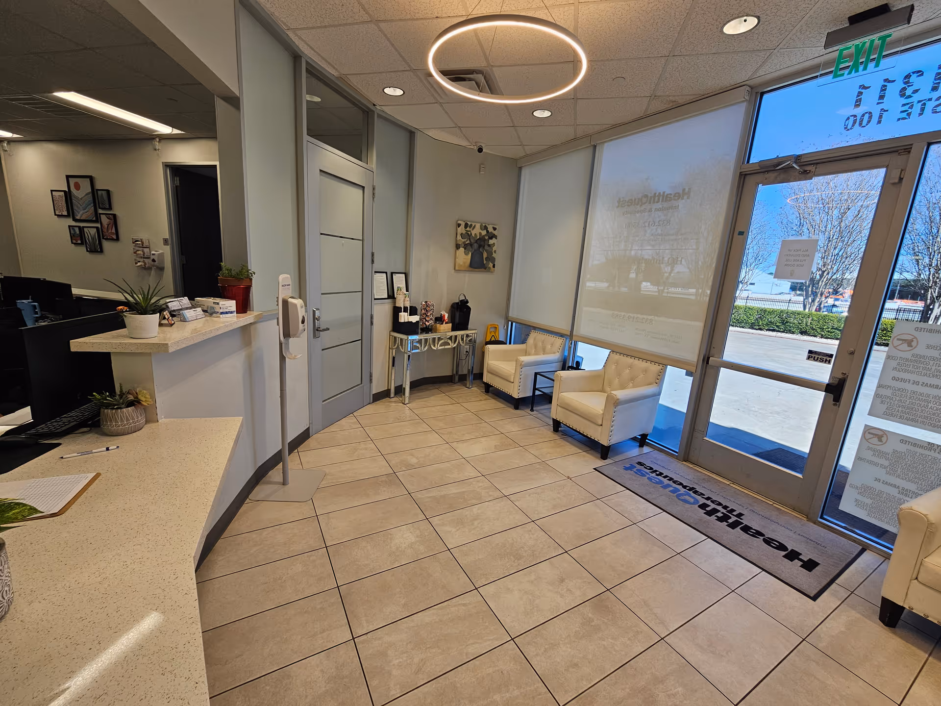 Interior reception lobby with curved counter, seating area, glass entrance doors at HealthQuest Infusion and Specialty.