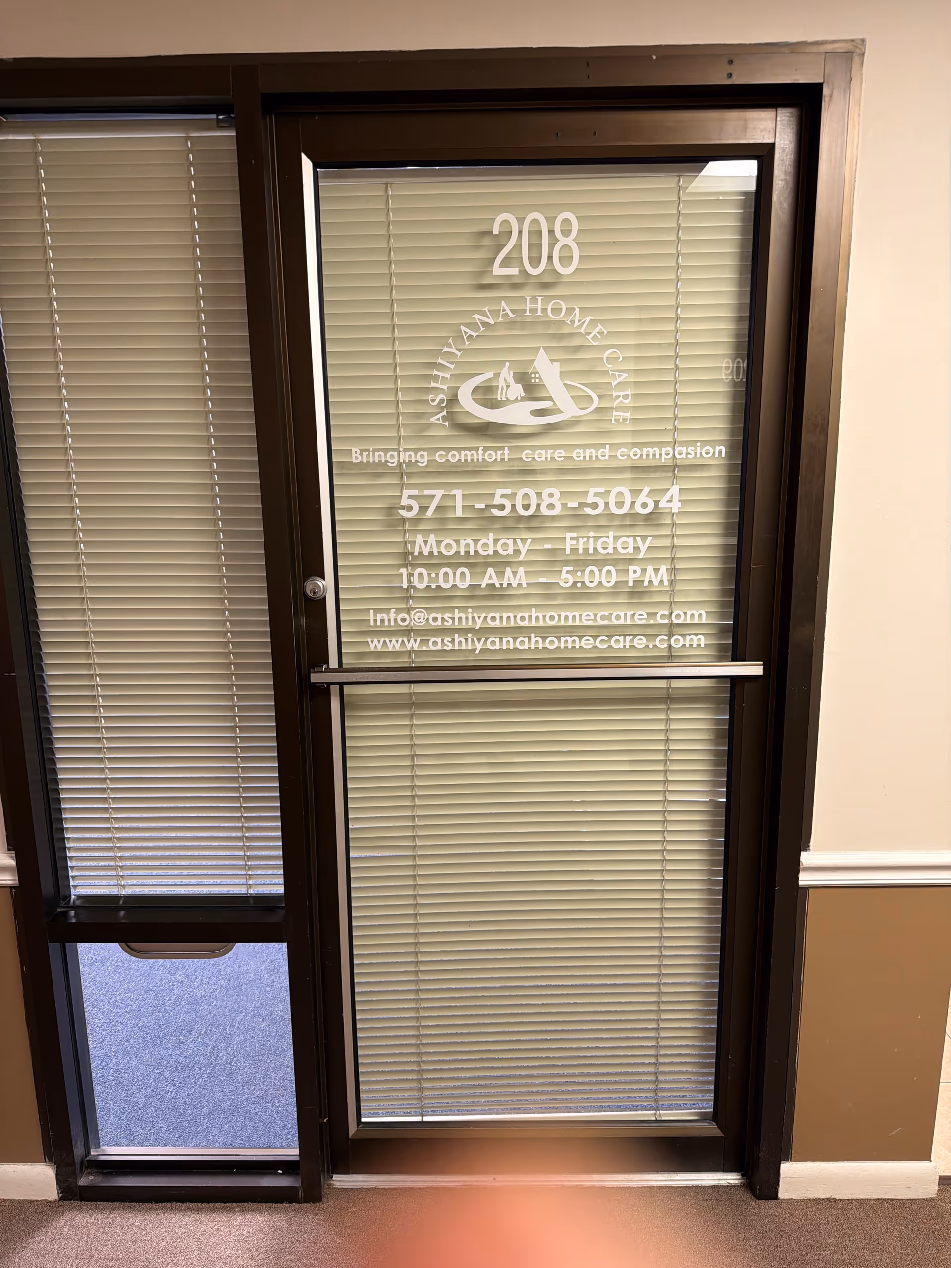 Glass door with blinds and Ashiyana Home Care branding, displaying 208 and contact details.