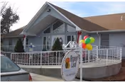 Exterior view of Aspen Leaf Assisted Living with front entrance and balloons.