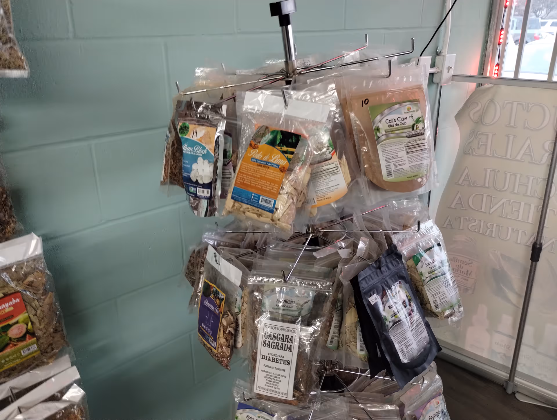 Interior view of a metal rotating display with assorted packaged snacks hanging.