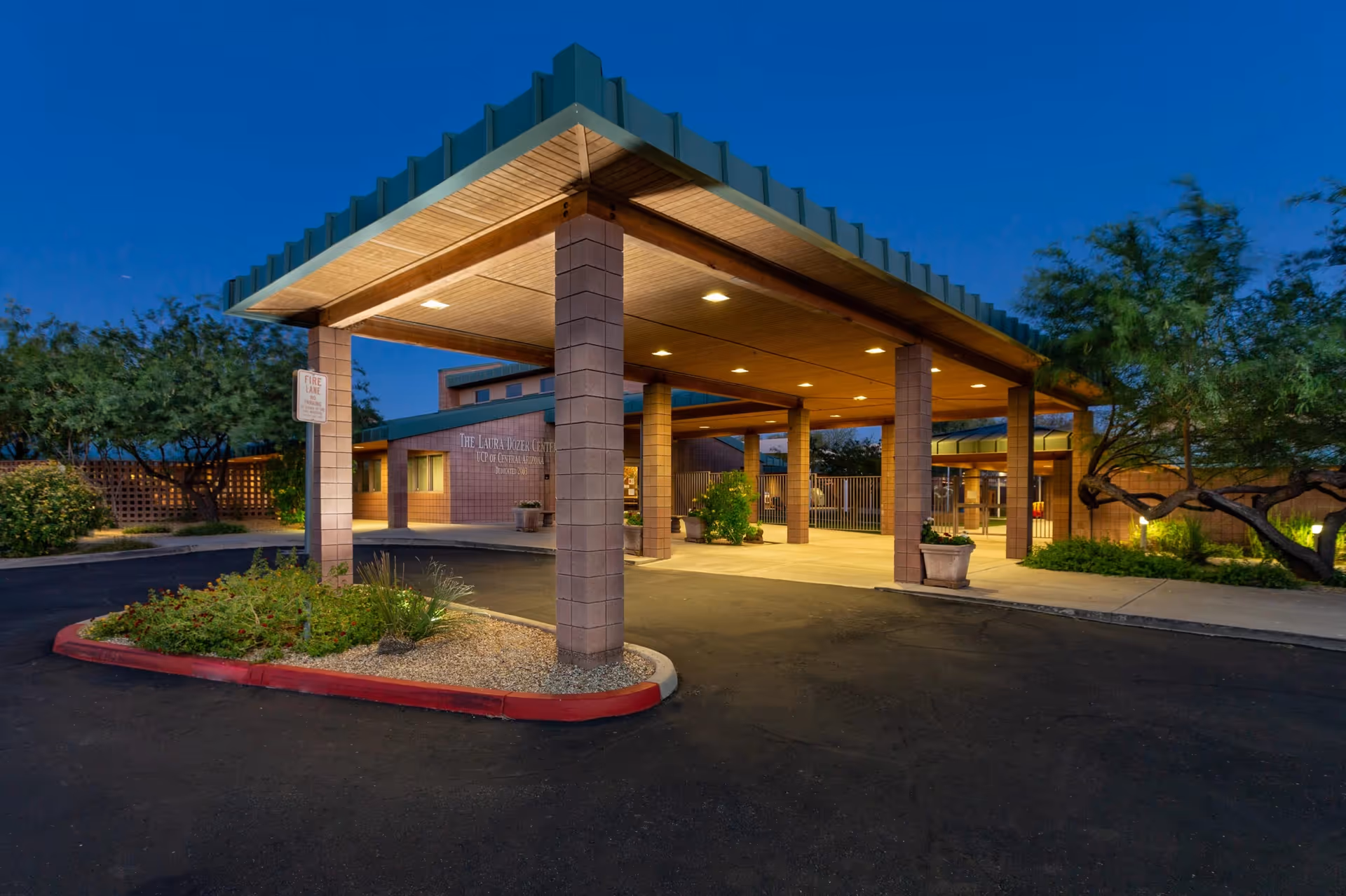 Exterior view of a senior living facility entrance with a covered drop-off area.