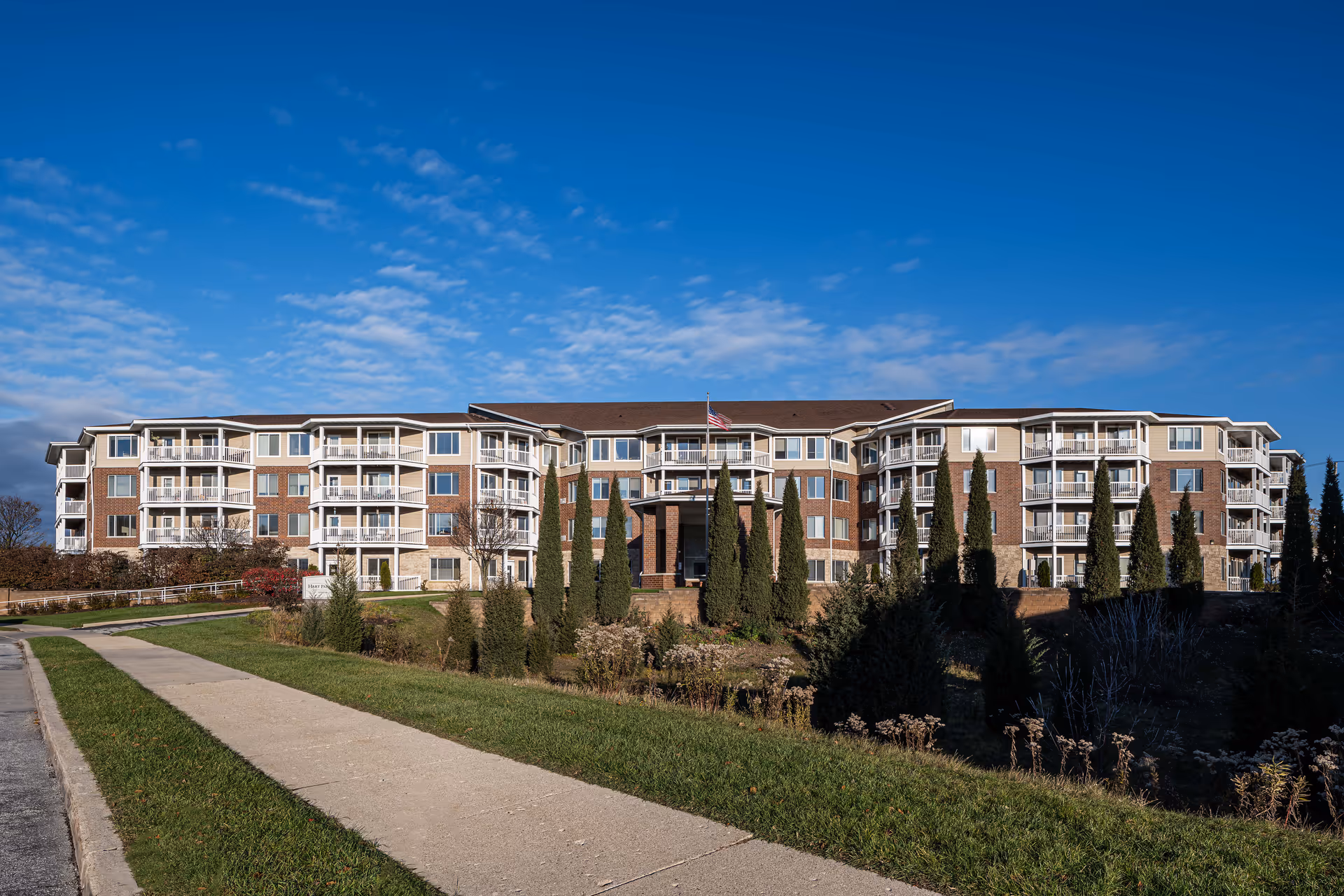 Wide shot of Hart Park Square Senior Living building with brick facade and landscaping.