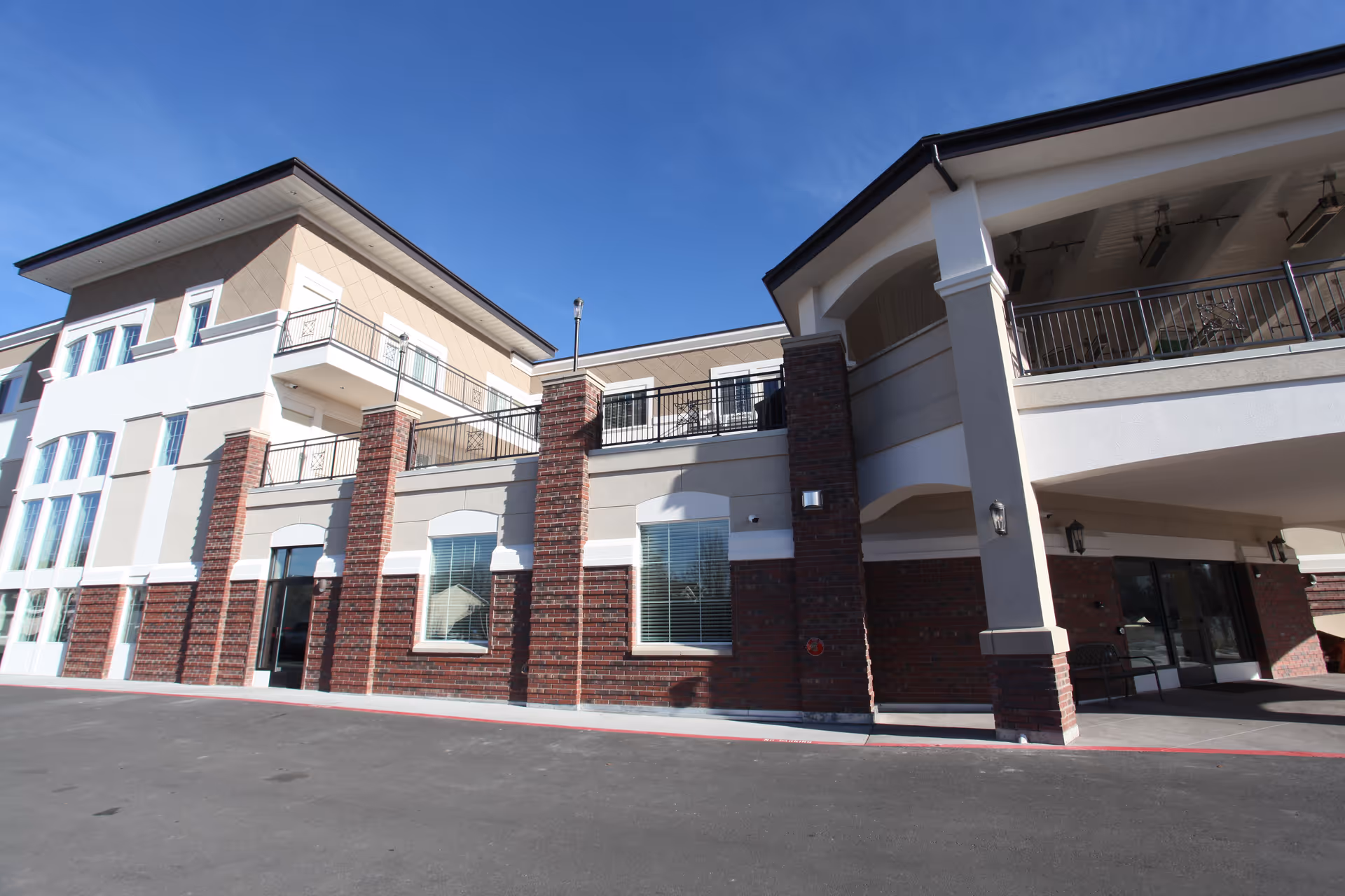Exterior view of Homestead Assisted Living building with brick columns and balconies.