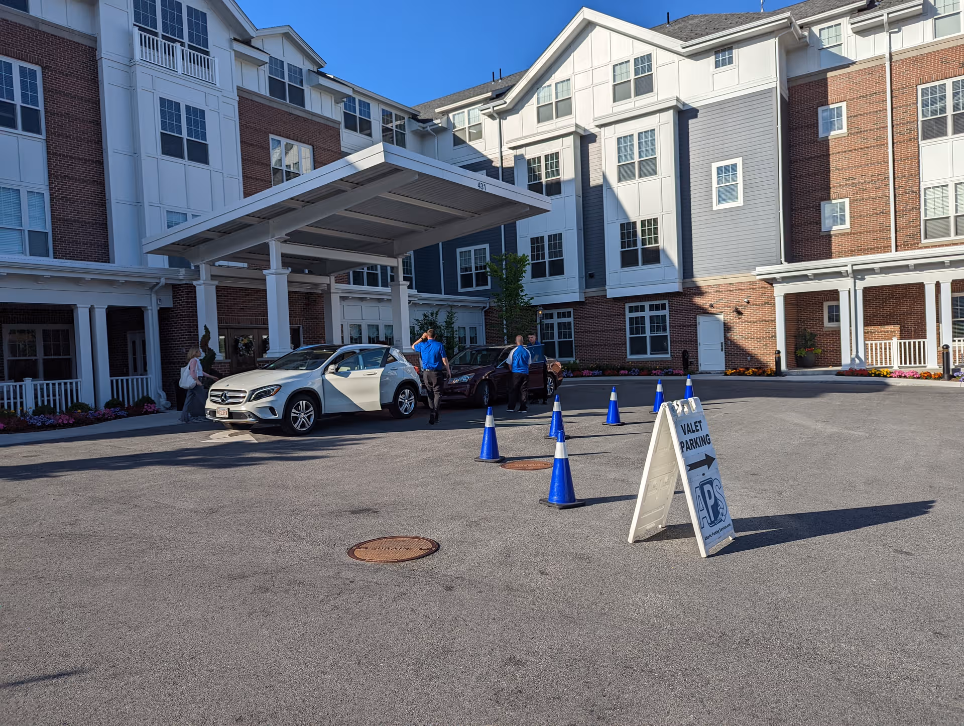 Sunrise of Newton exterior shows a covered entrance, parked cars, and a valet sign.