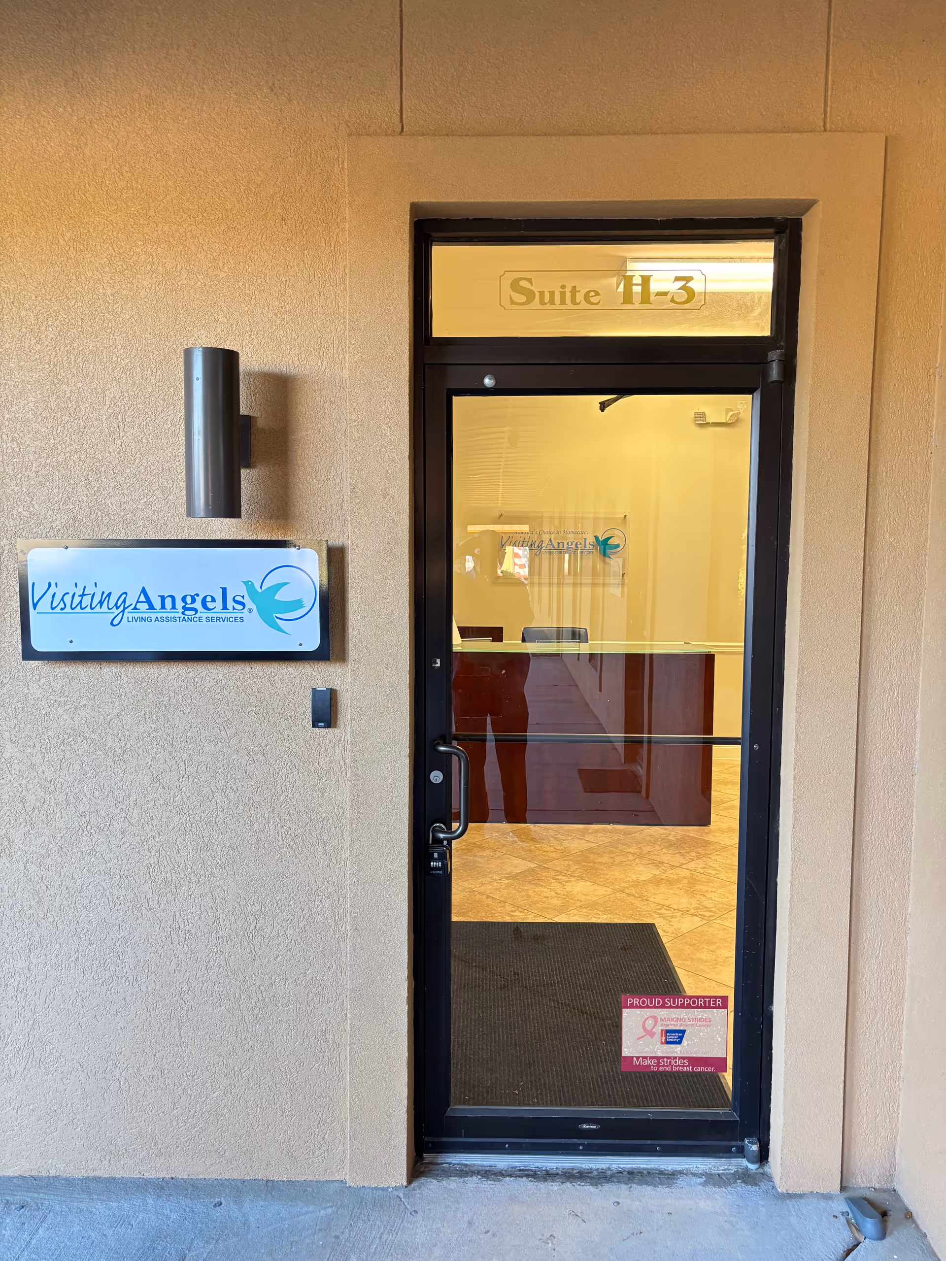 Exterior doorway to Visiting Angels office; suite H-3 sign and wall logo visible.