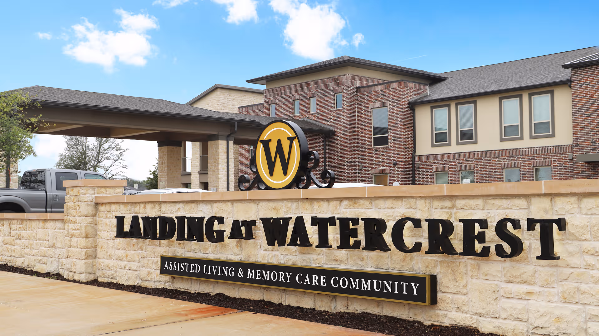 Exterior view of Landing at Watercrest sign with brick building entrance.