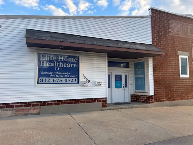 Front view of a small healthcare facility with blue signage and white siding.