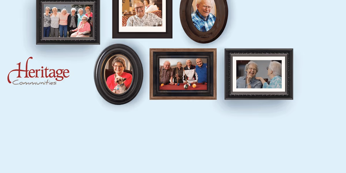 Light blue wall adorned with multiple framed photos and a Heritage Communities logo.