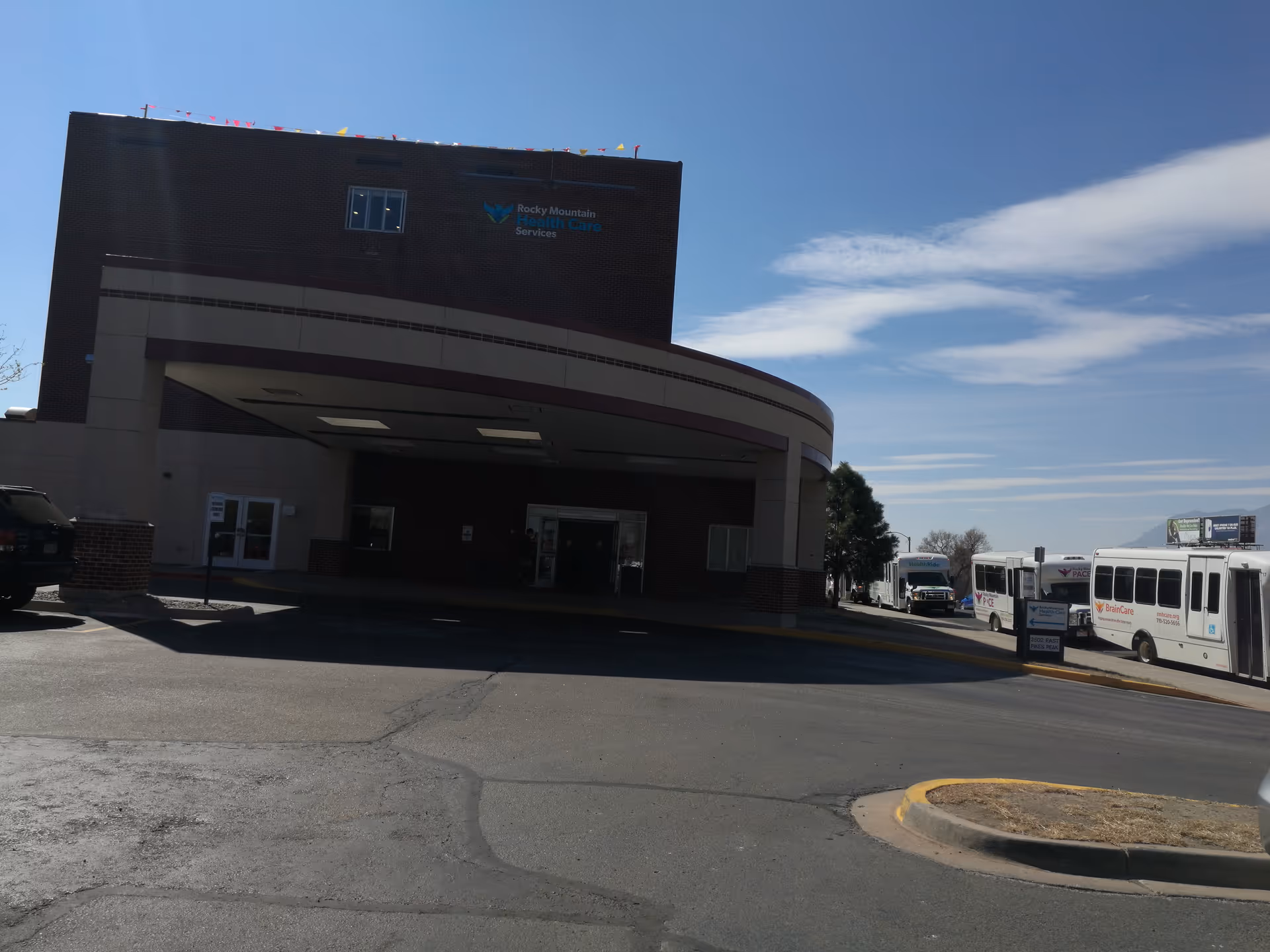 Exterior view of Rocky Mountain Health Care Services building with buses parked outside.