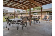 Outdoor covered patio with metal tables and chairs at Valley Manor Care Center.