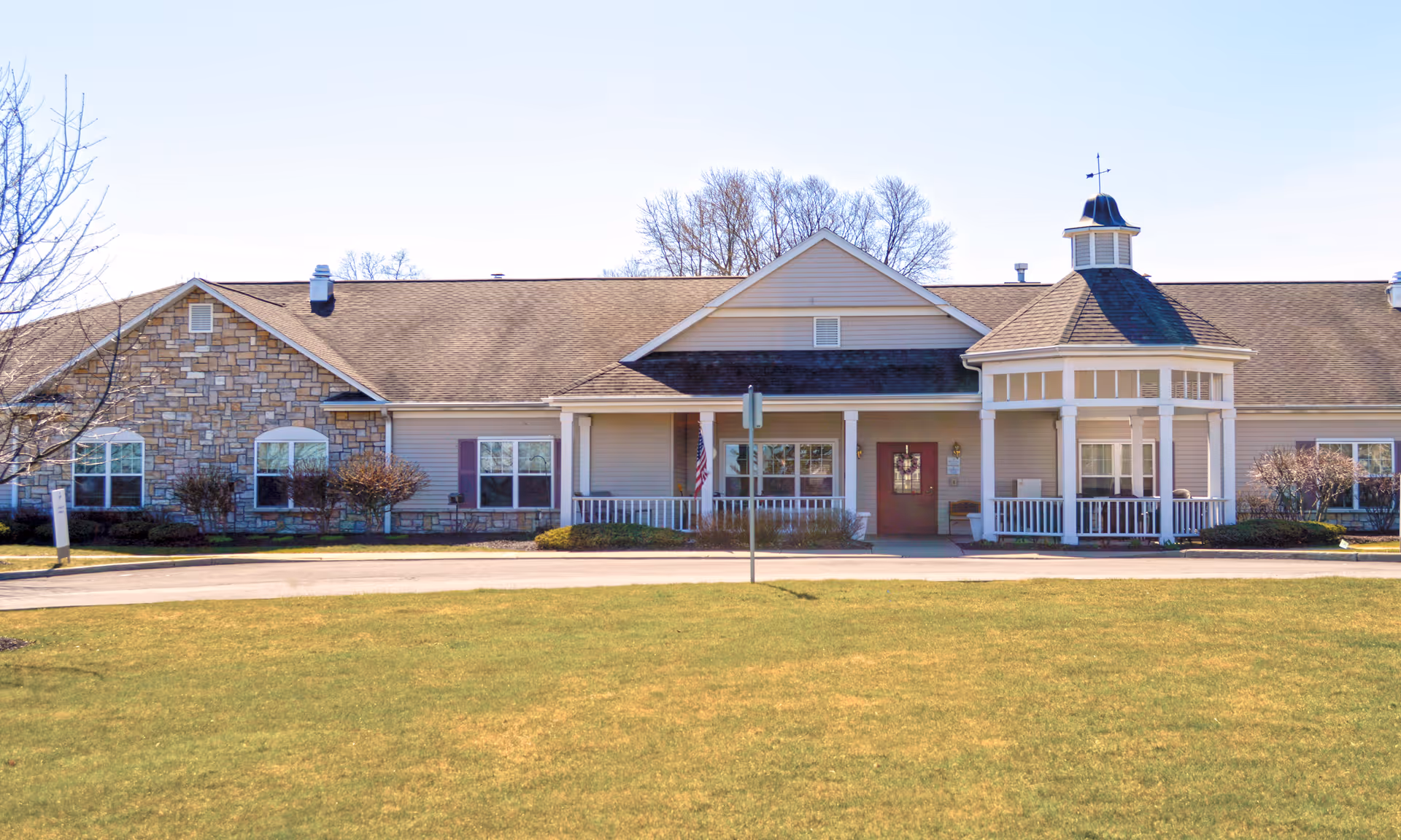 Front view of Brookdale Ithaca Assisted Living facility with a covered porch and lawn