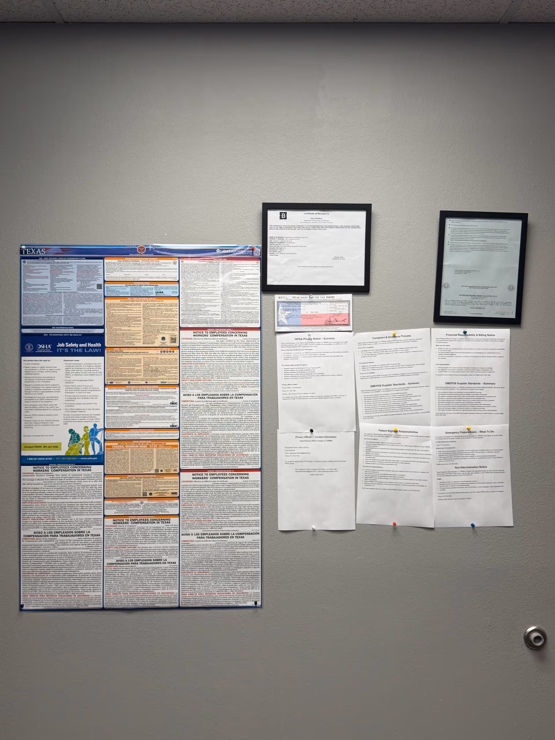 Interior wall with framed notices and large information posters.