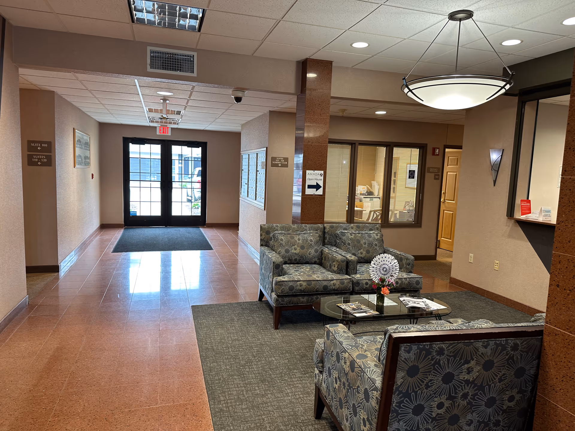 Lobby seating area with patterned couches and glass coffee table near the entrance.