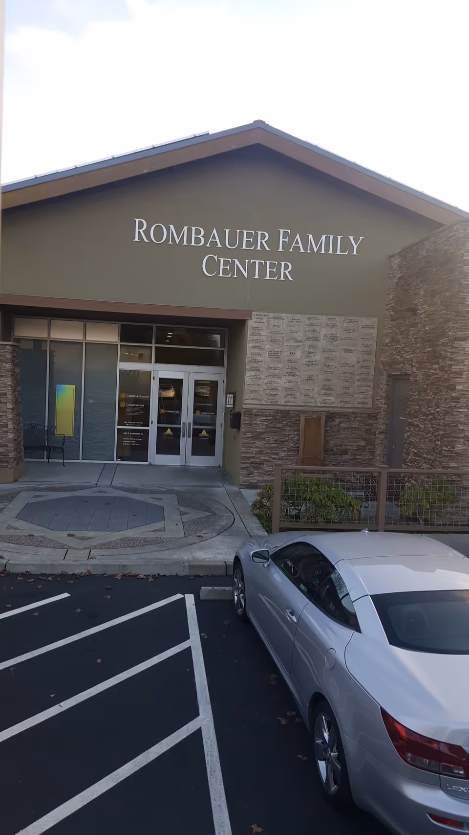 Front facade of Rombauer Family Center with glass doors and a parked silver car.