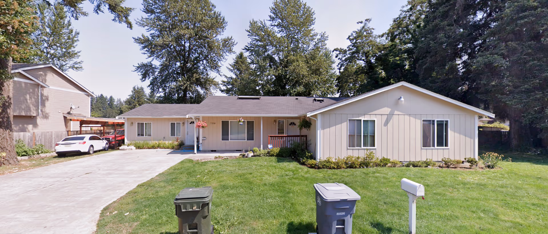 Front view of a single-story adult family home with a driveway and green lawn.