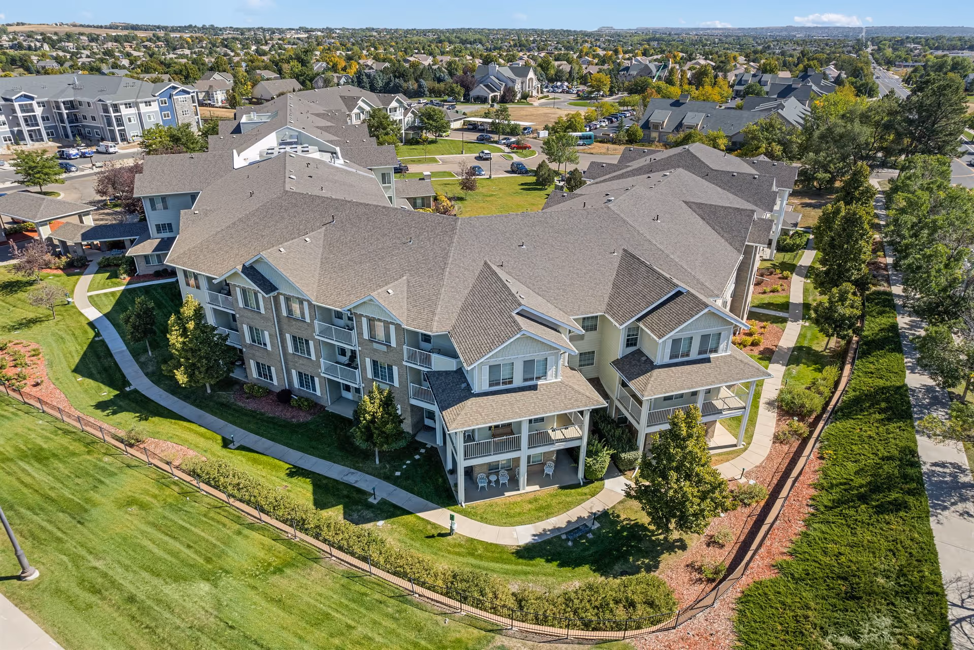 Aerial view of a multi-building senior living campus with green lawns and pathways.