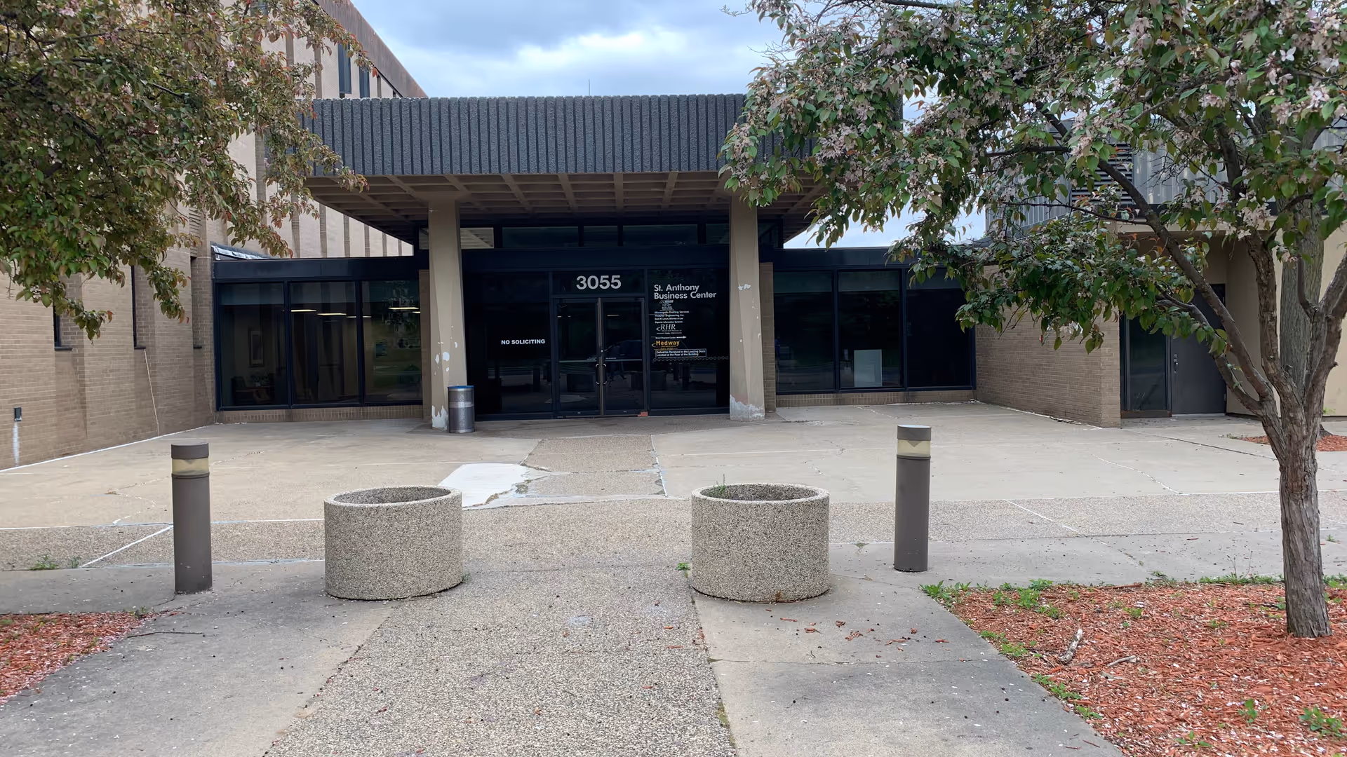 Exterior of Happy Home Care facility entrance with glass doors and trees