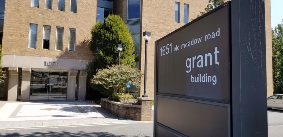 Exterior view of a brick building entrance with a large sign that says grant building