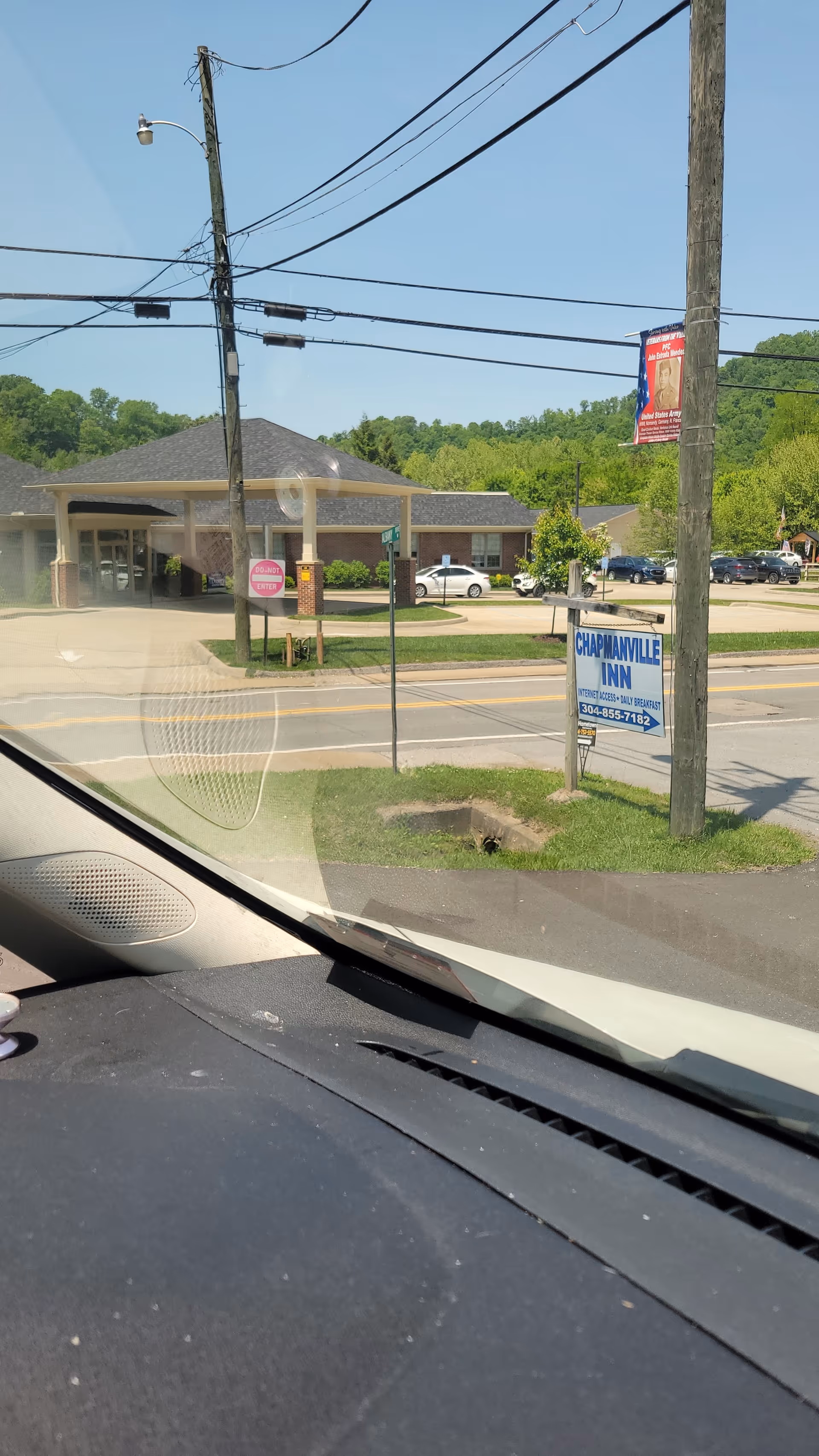 Exterior view of a building with a parking lot, seen from inside a car.