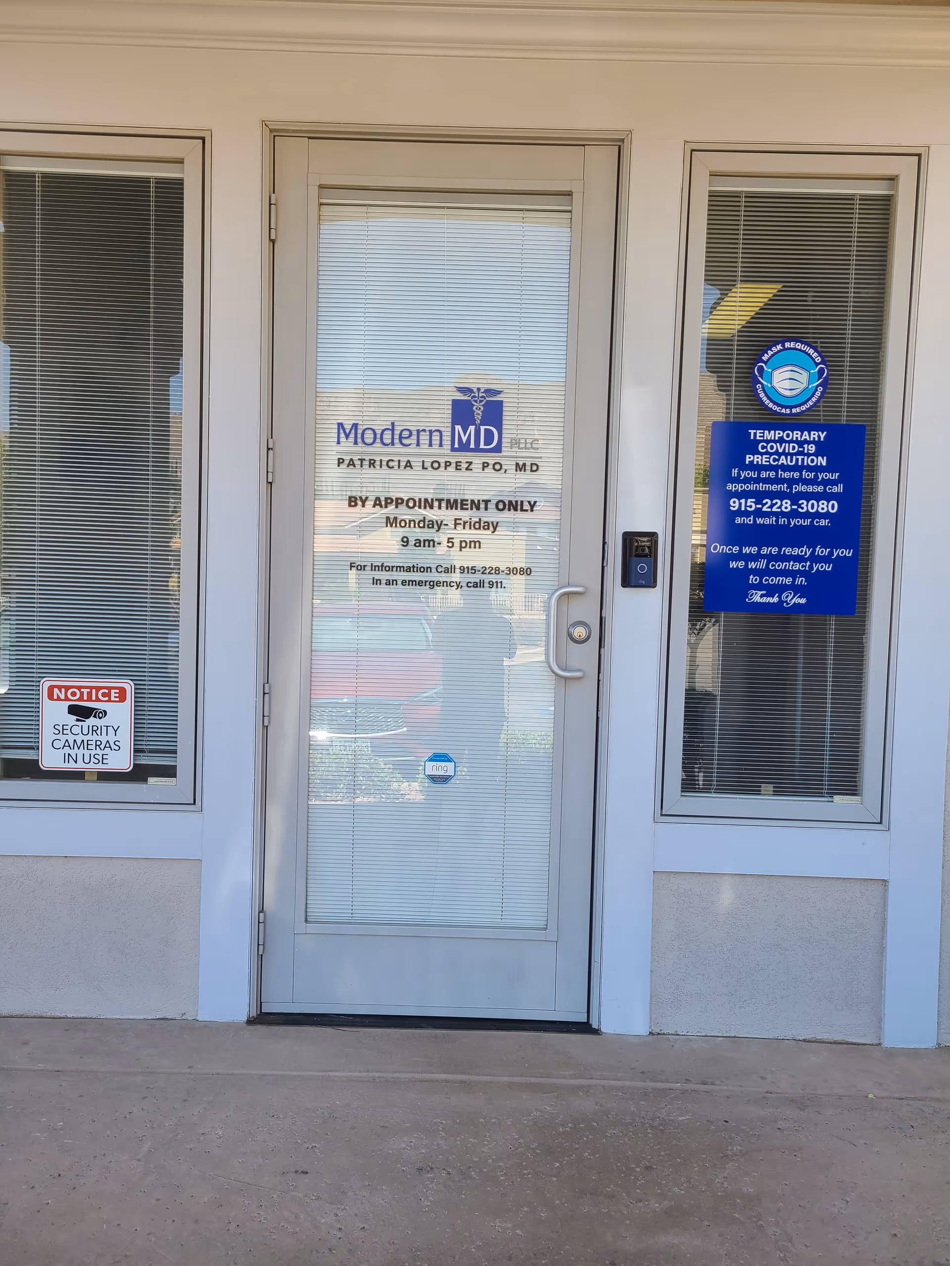 Front entrance of Modern MD clinic with glass door, windows, and signs