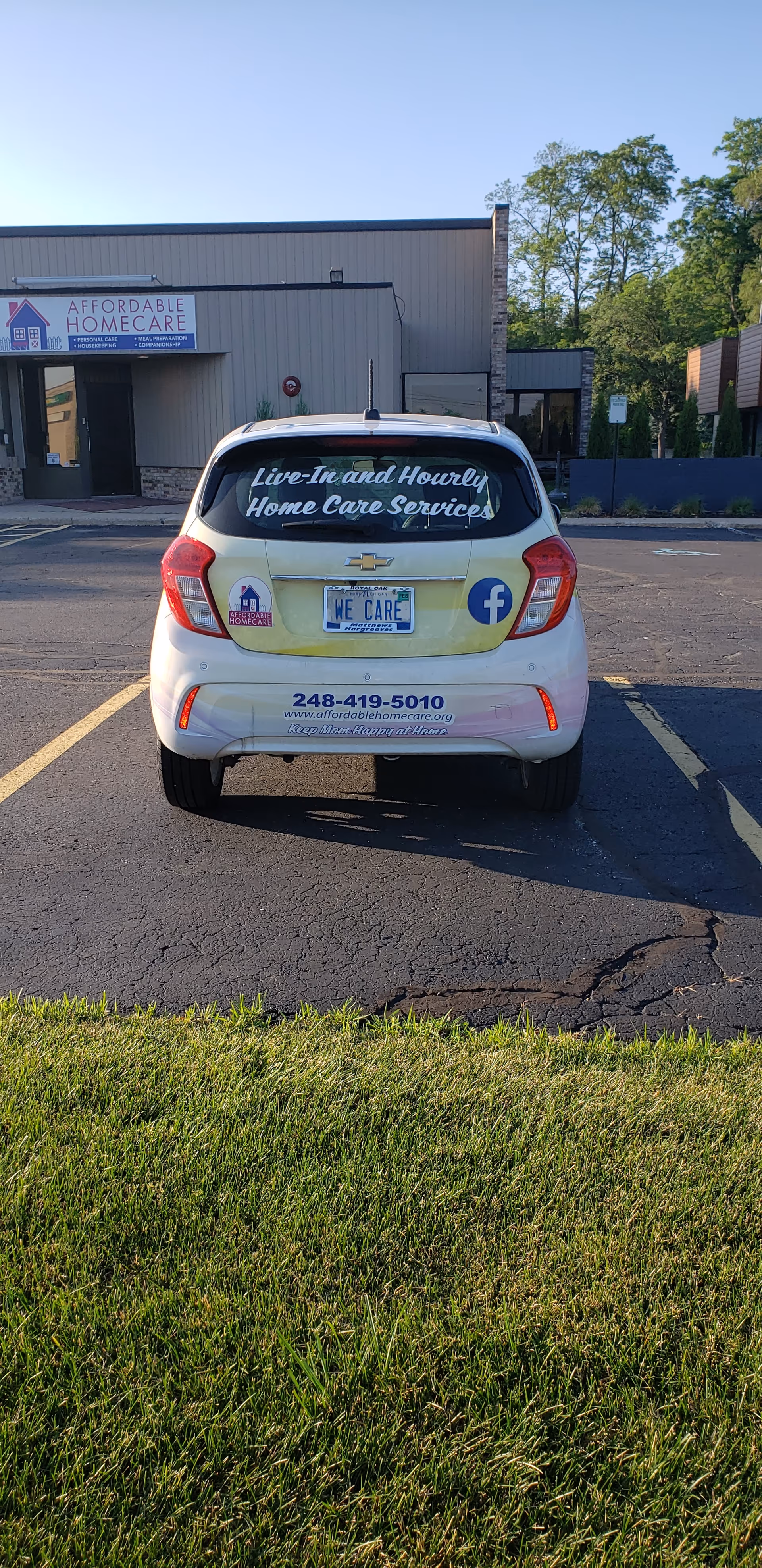 Rear view of a white car in a parking lot, Affordable HomeCare building visible behind.