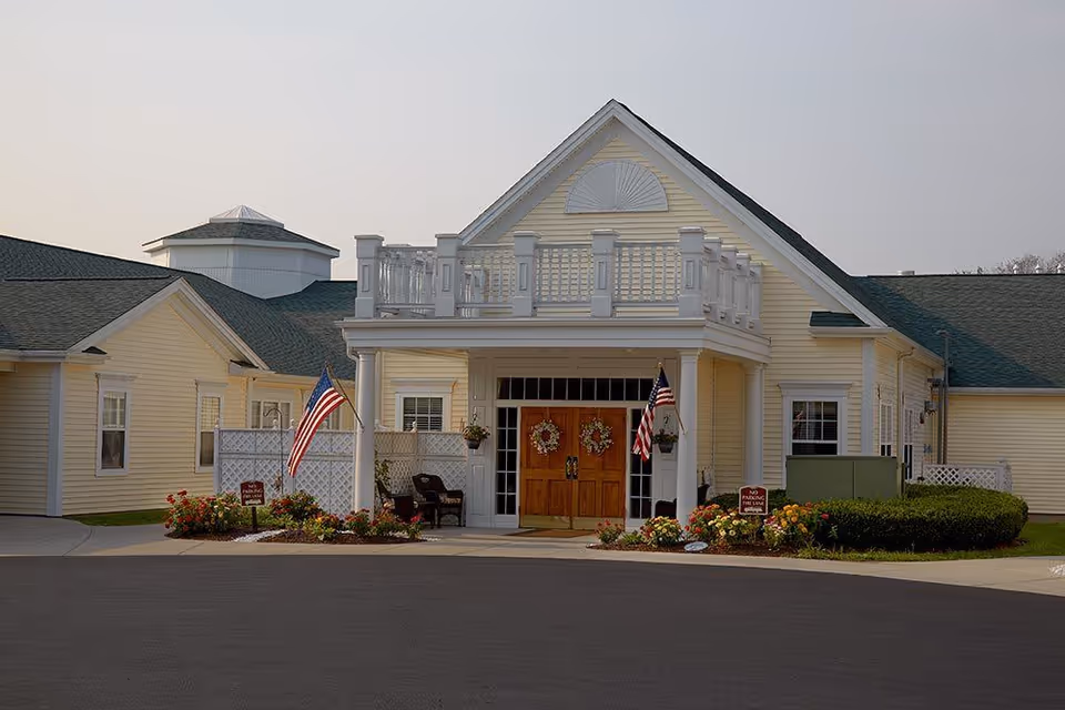 Front exterior of a yellow senior living facility with a covered entrance.