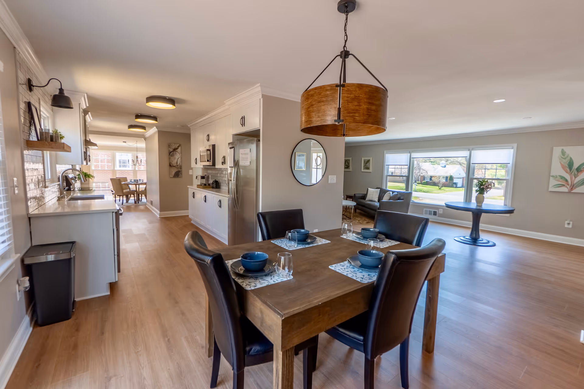 Open-concept dining area and kitchen with living space and large windows.
