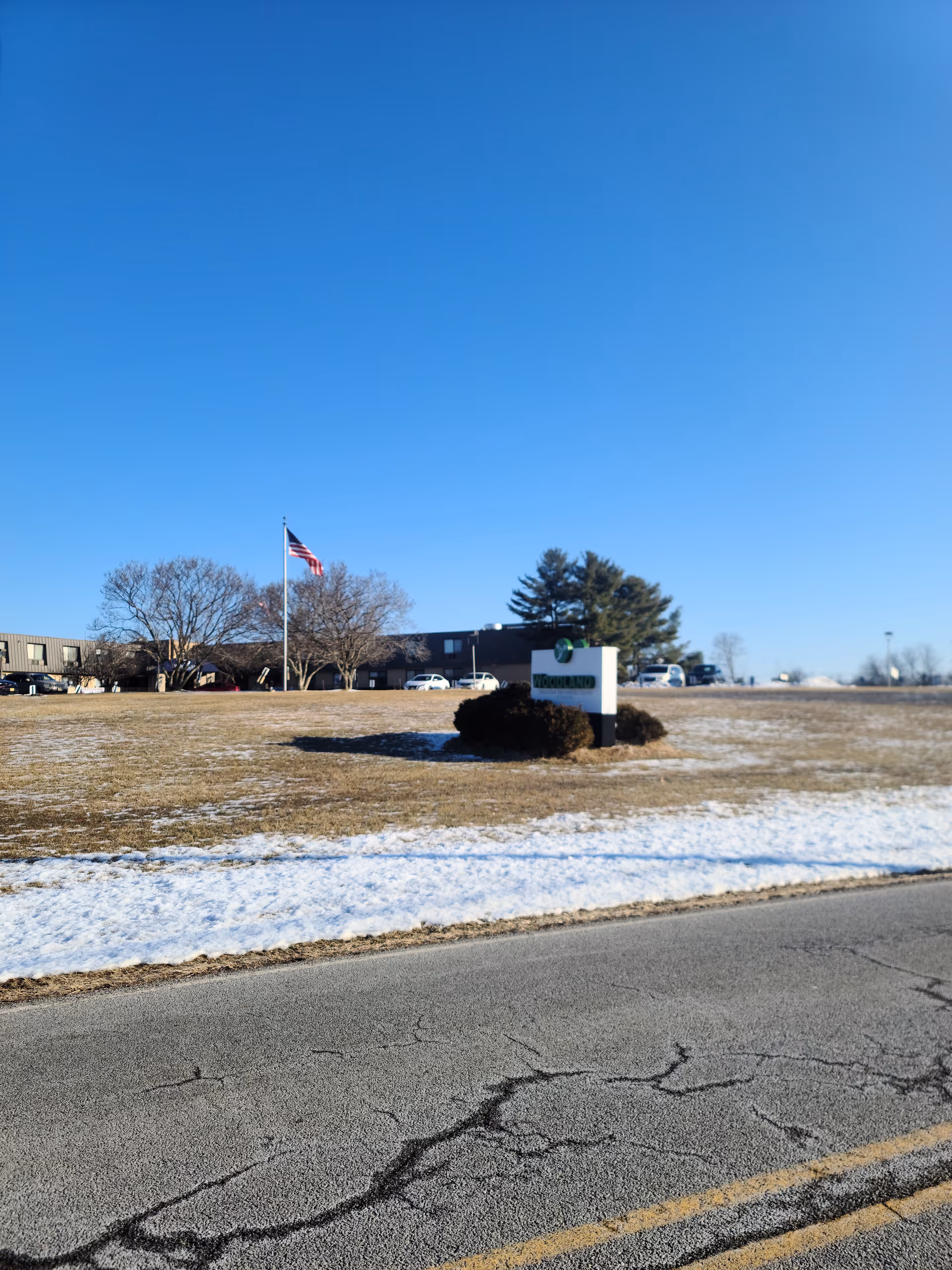 Exterior view of Andover Subacute and Rehab II building with flag and sign.