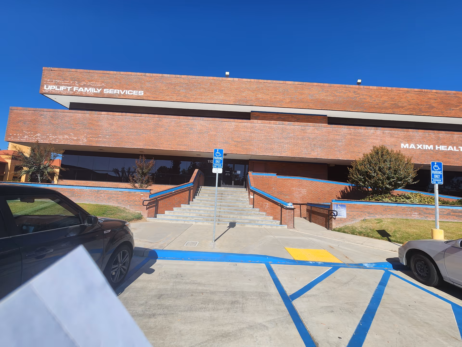 Brick building front labeled Maxim Healthcare, Fresno; stairs to entrance with handicap parking.