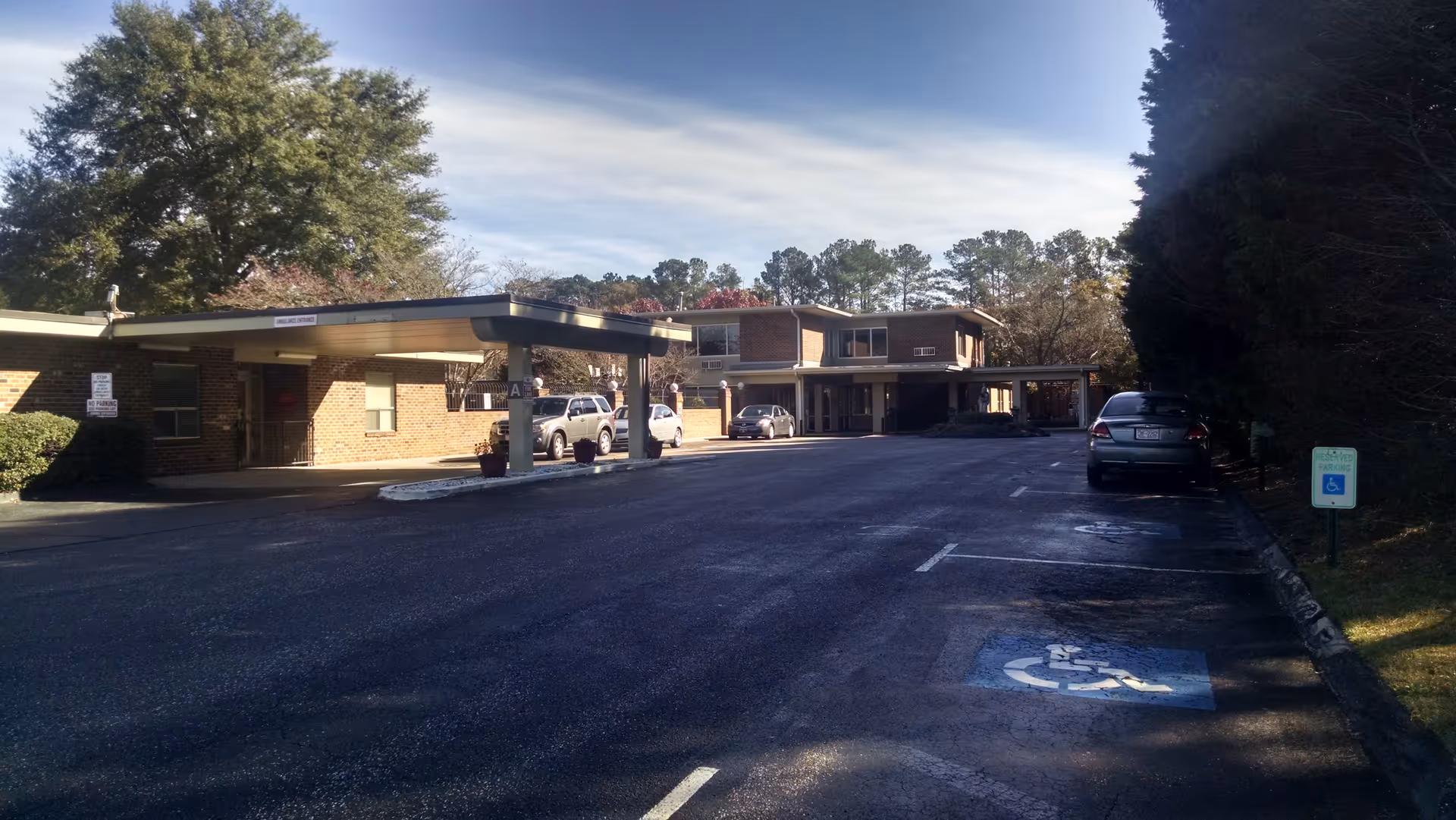 Brick senior living facility with a covered entrance and surrounding parking lot.