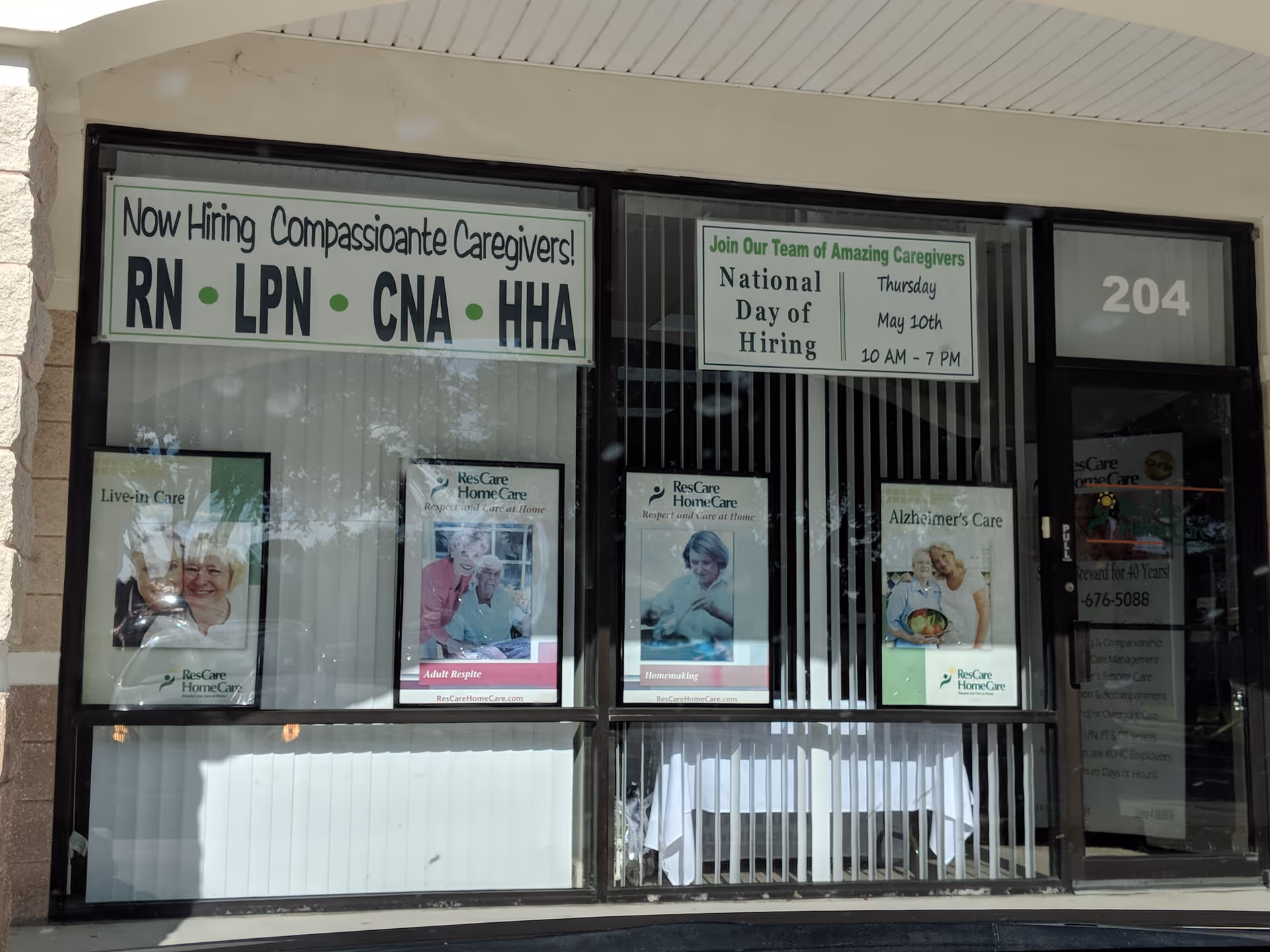 Storefront window displaying caregiver job banners and home care posters.