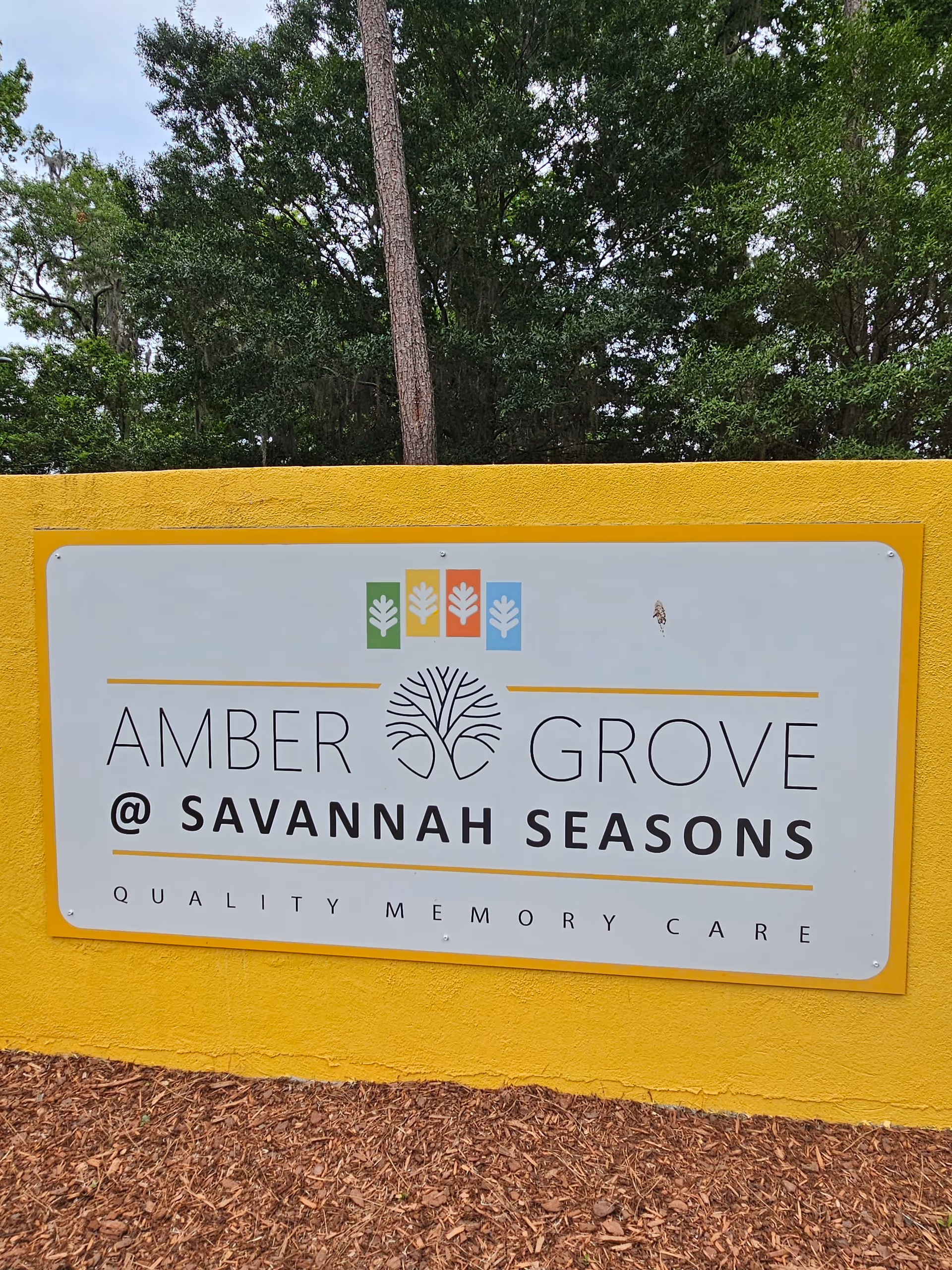 Outdoor sign reads Amber Grove at Savannah Seasons on a yellow wall.