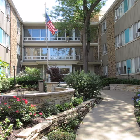 Outdoor courtyard at Zahav of Berwyn with walkway, greenery, and flag.