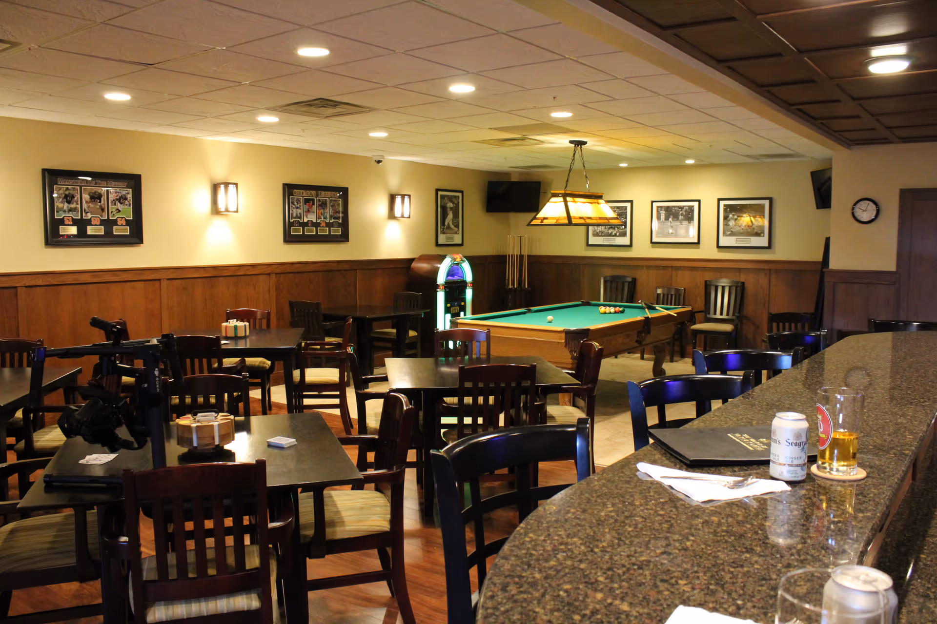 Interior common area with pool table, bar counter, and tables and chairs in a lounge.